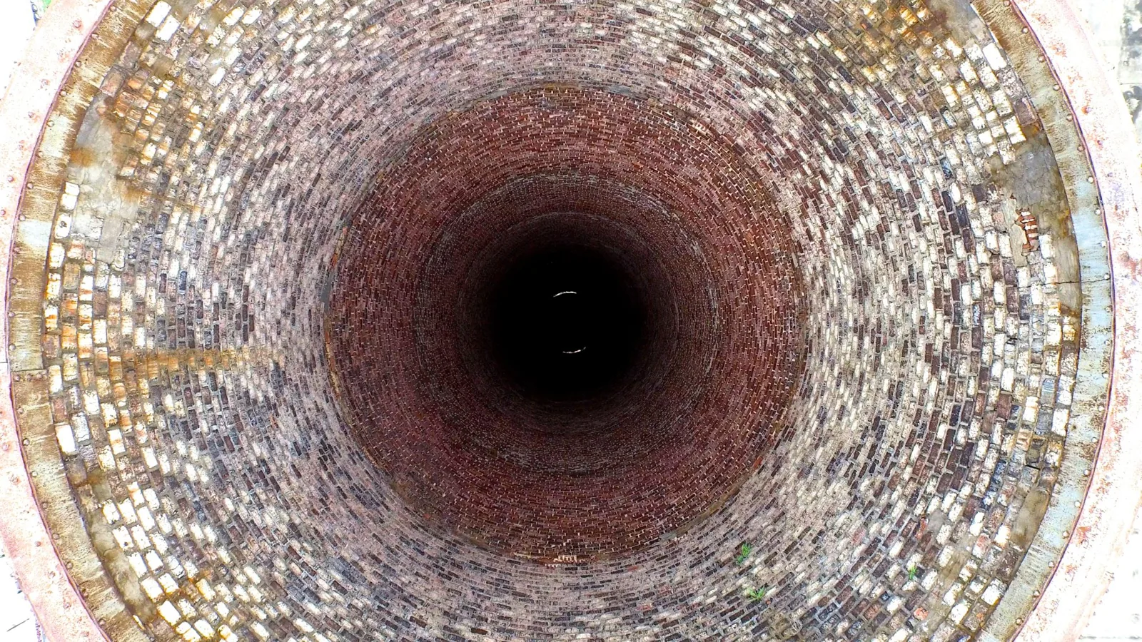 Aerial view looking straight down the brick-lined shaft of a disused power station chimney