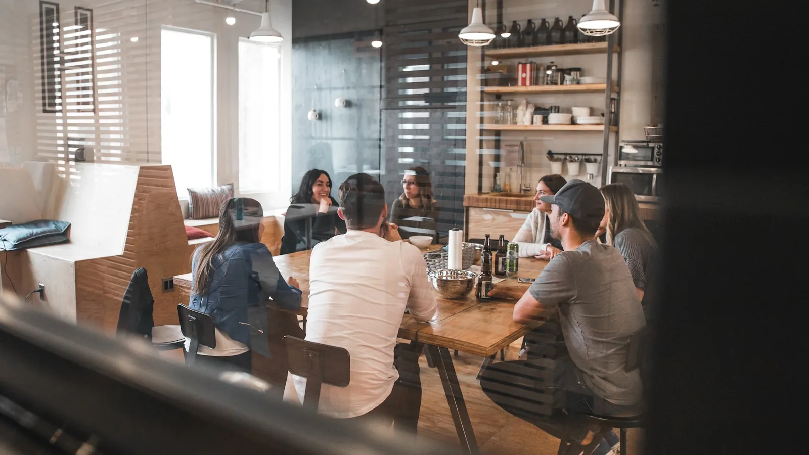 A group of people seated around a long table in a meeting, representing the design decisions behind meaningful AI oversight