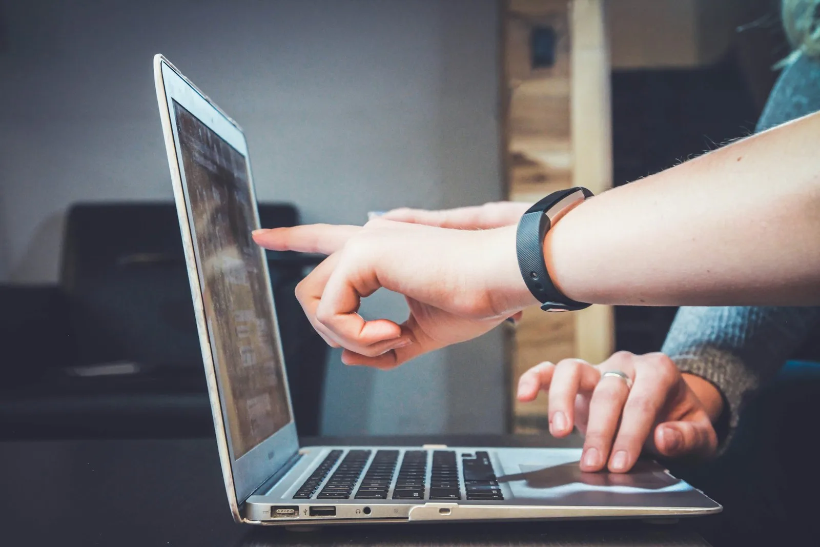 Two colleagues looking at a laptop screen together, one pointing, representing a reviewer exercising a real right of refusal