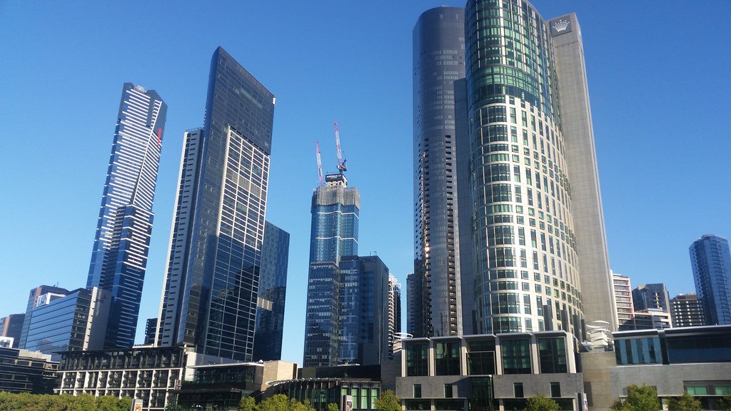 Melbourne CBD skyline in daylight with construction cranes rising between the towers