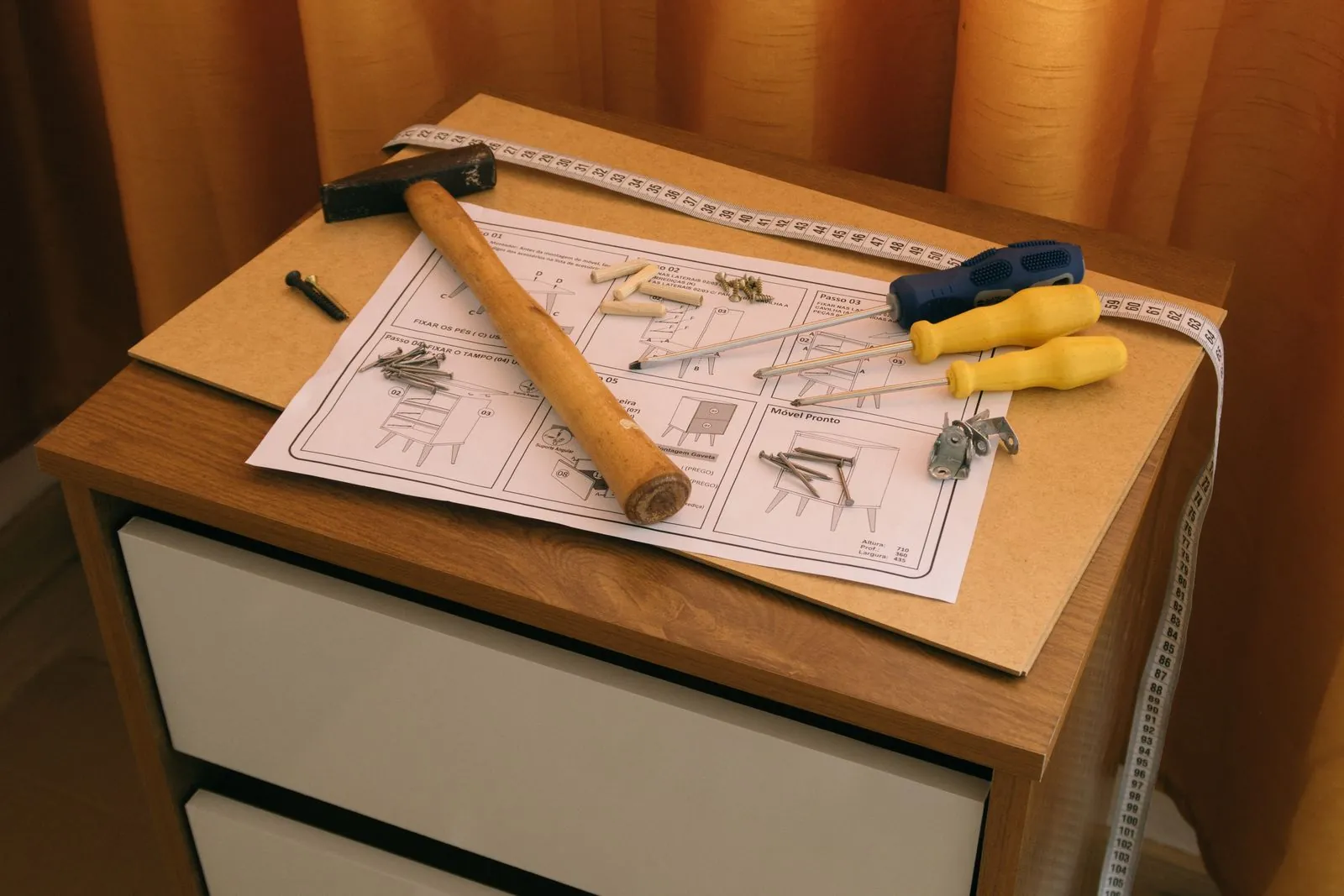 Flat-pack assembly instructions on a half-built timber bedside cabinet with a hammer, screwdrivers and screws: the build vs buy AI choice in furniture form