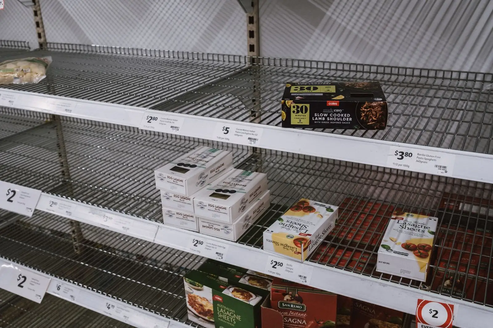 Wire shelves left almost empty after a stockout, with only a few packets remaining