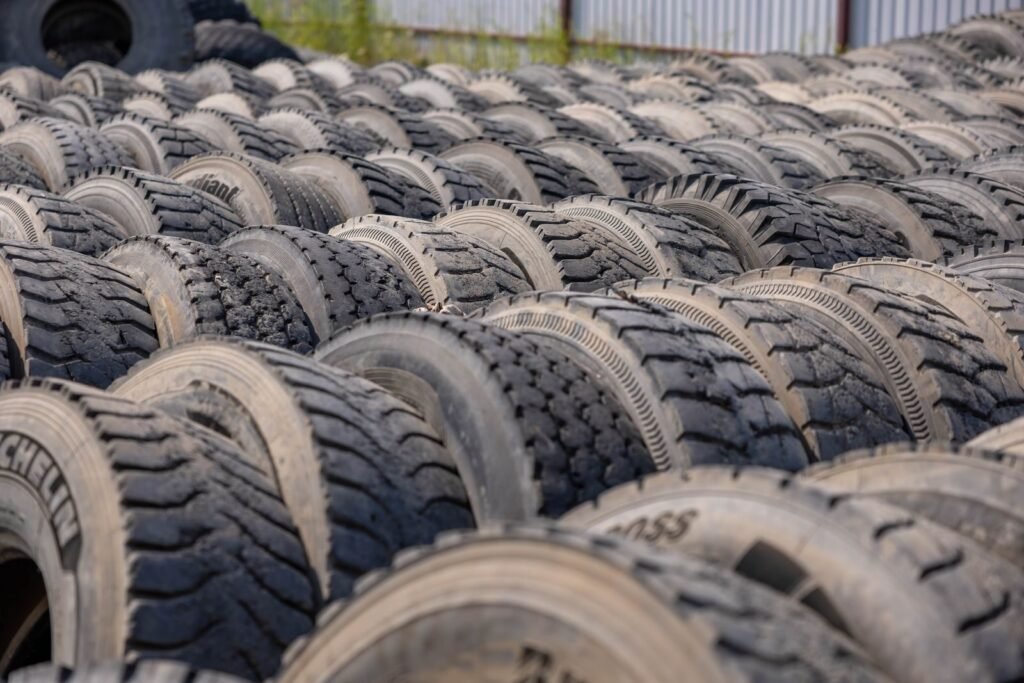 Rows of used truck tyres stacked in an outdoor storage yard, the kind of load that needs Waste Tracker records before it moves
