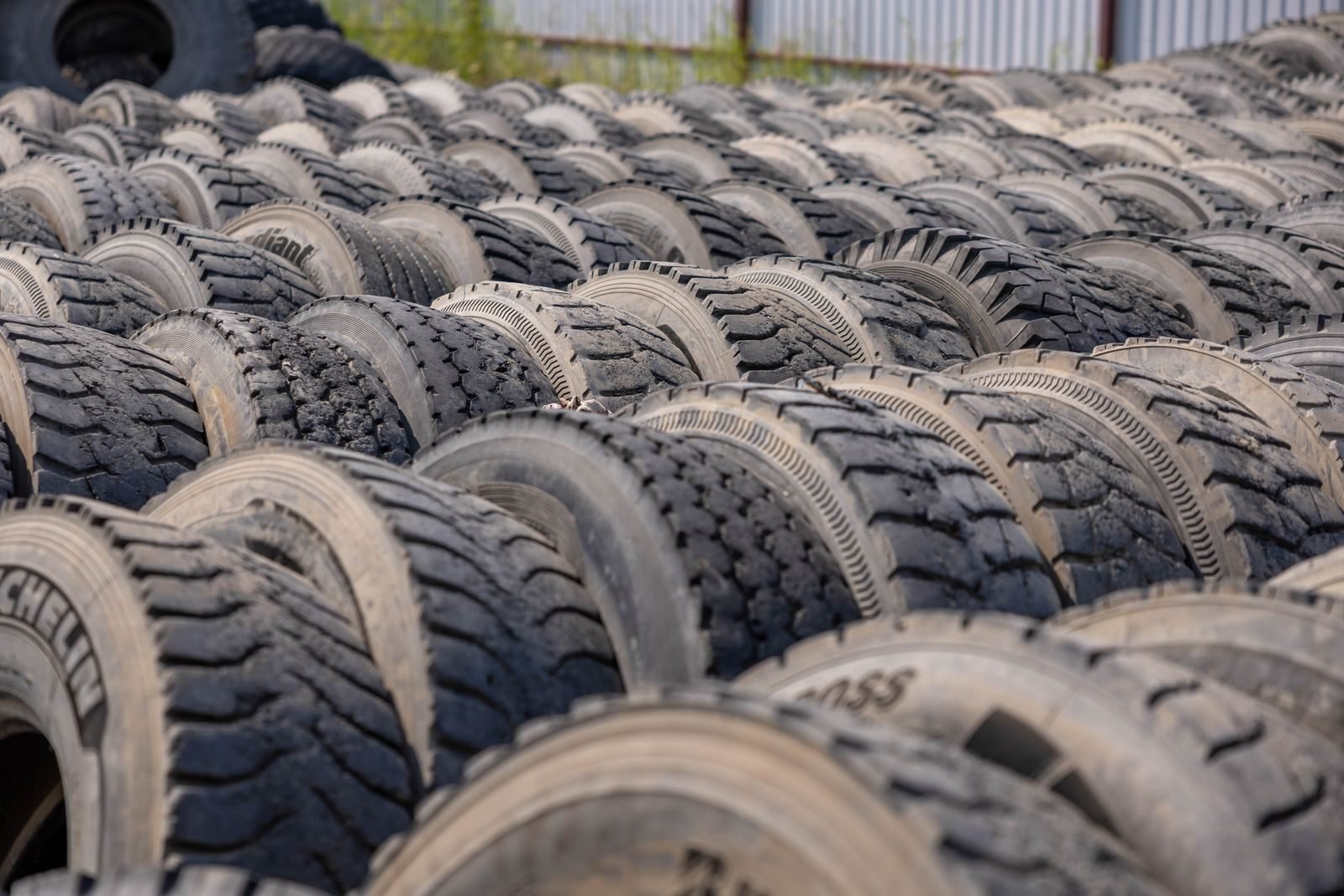 Rows of used truck tyres stacked in an outdoor storage yard, the kind of load that needs Waste Tracker records before it moves