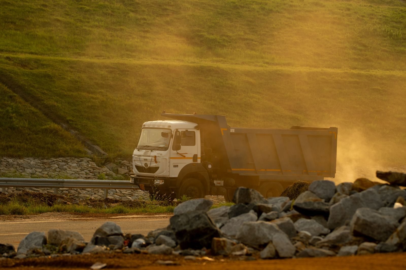 A truck driving along a dusty road at sunset, the transport leg covered by Waste Tracker records
