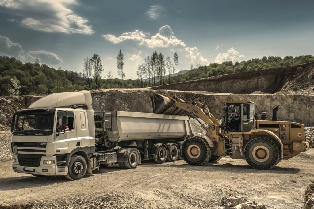 Tipper truck being loaded by a front end loader at a quarry yard